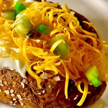 Steakhouse baked potato topped with sour cream, cheese and chives