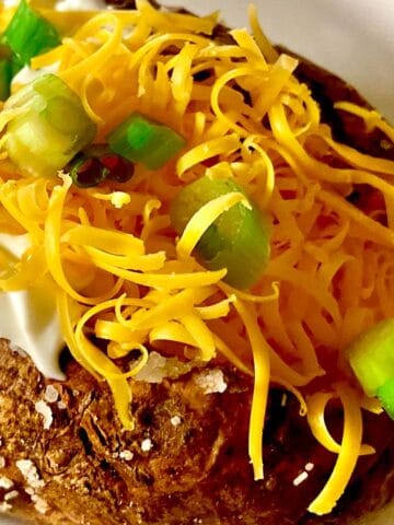 Steakhouse baked potato topped with sour cream, cheese and chives