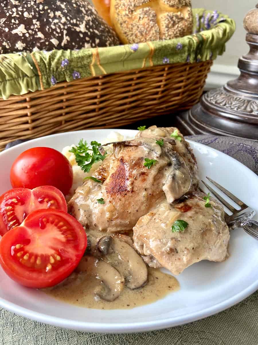 Chicken Fricassee on white plate with sliced cherry tomatoes