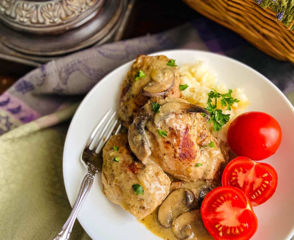 Chicken Fricassee on white plate with rice and tomatoes