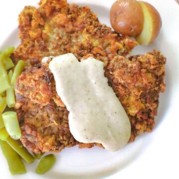 Chicken fried steak with cream gravy and a side of green beans