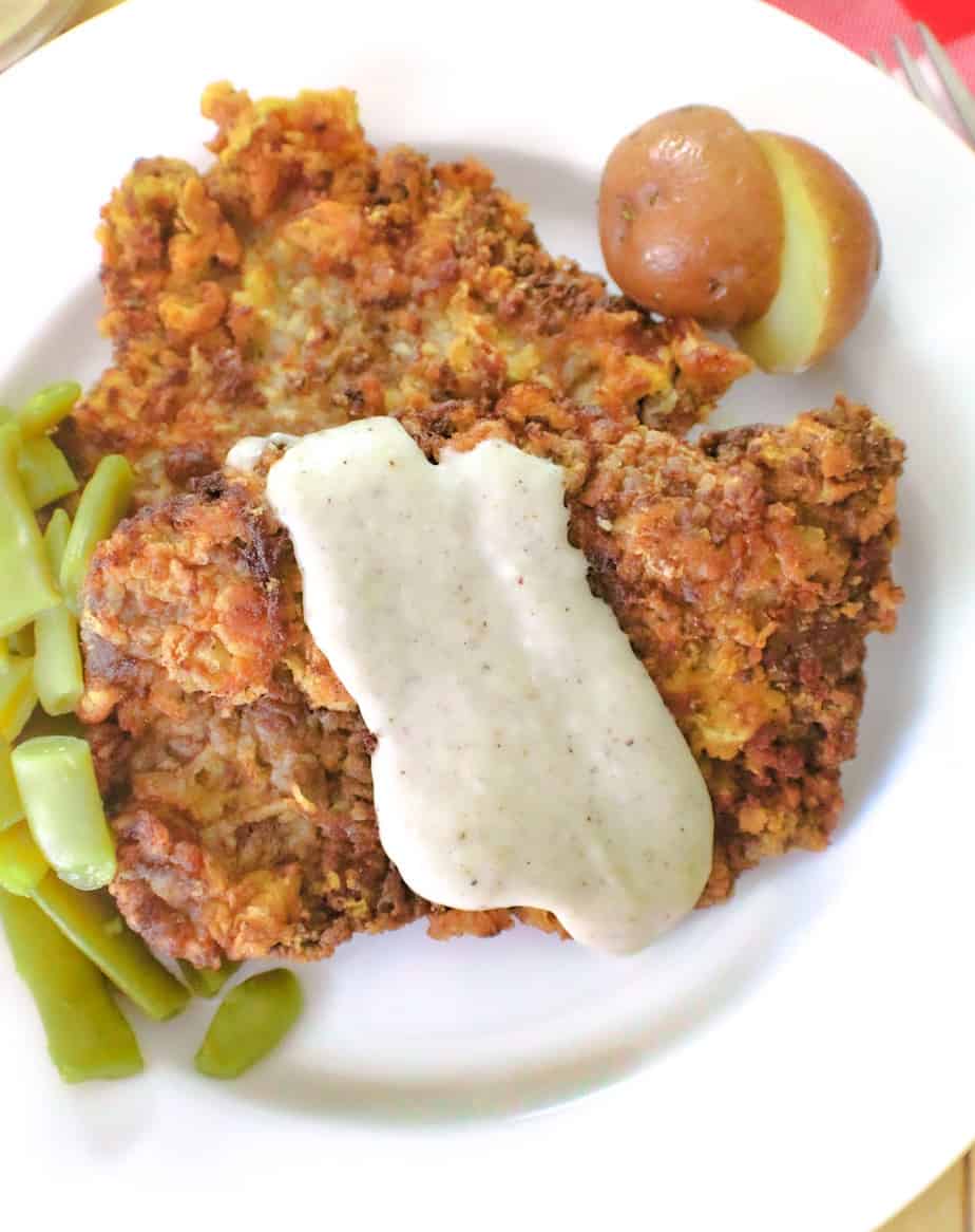 Chicken fried steak with cream gravy and a side of green beans