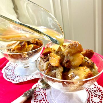 Whiskey sauce drizzled over bread pudding in fluted glass bowl