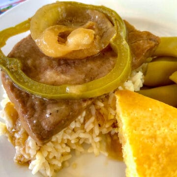 Smothered Steak with Brown gravy, onions and peppers over rice with a side of green beans and cornbread