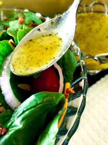 White Balsamic Vinaigrette being drizzled over spinach salad