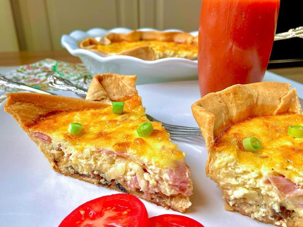 Two slices of quiche on white plate.