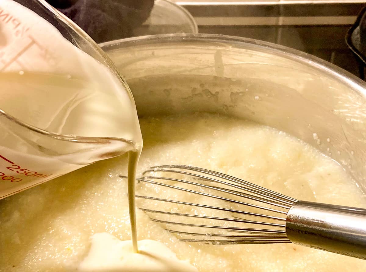 Heavy cream being added to grits.