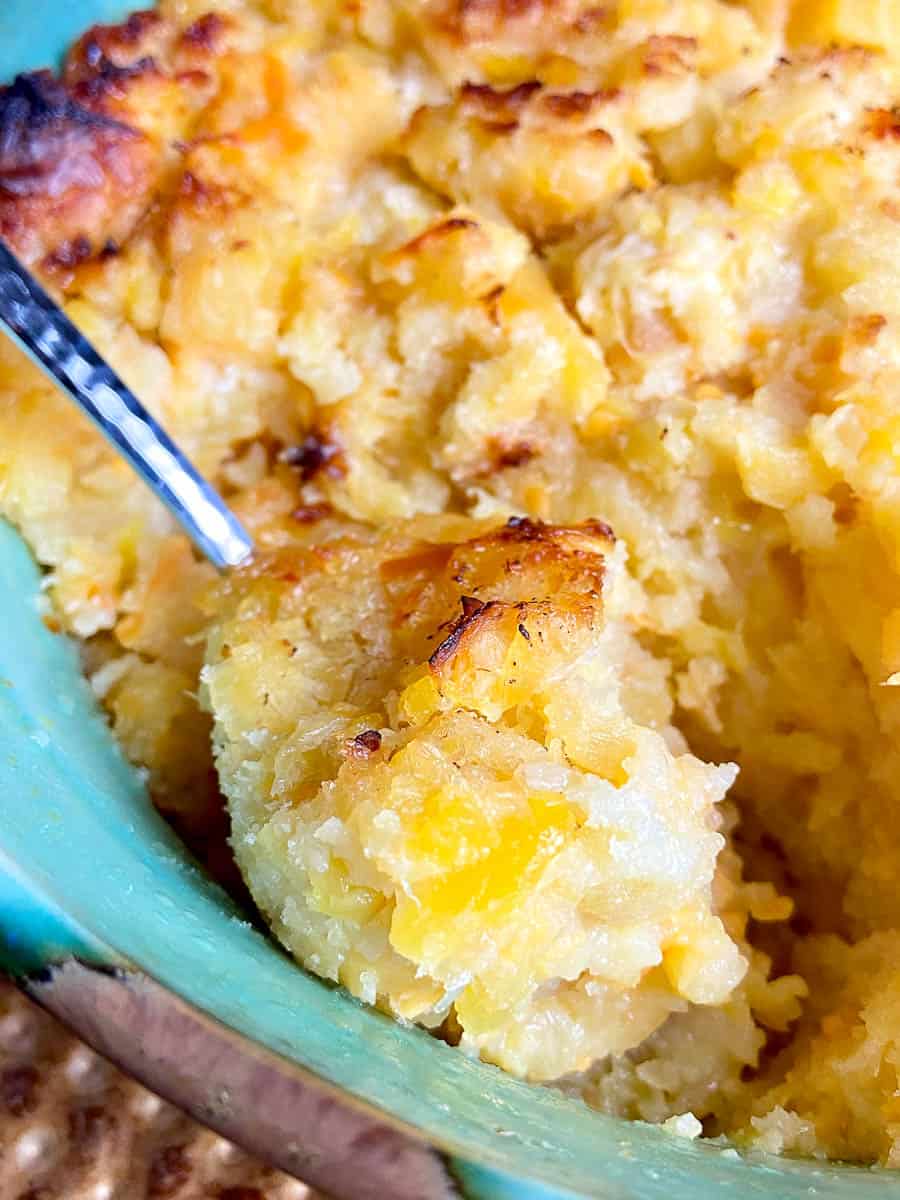 Spoonful of pineapple bread casserole being scooped out.