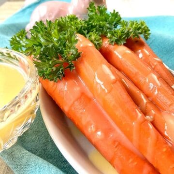 Orange glazed carrots in white bowl