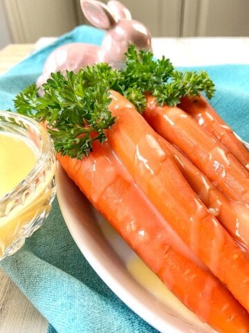 Orange glazed carrots in white bowl