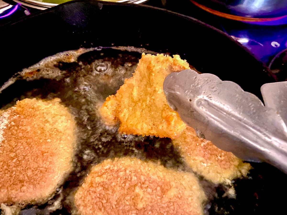 Pork Schnitzel frying in pan.