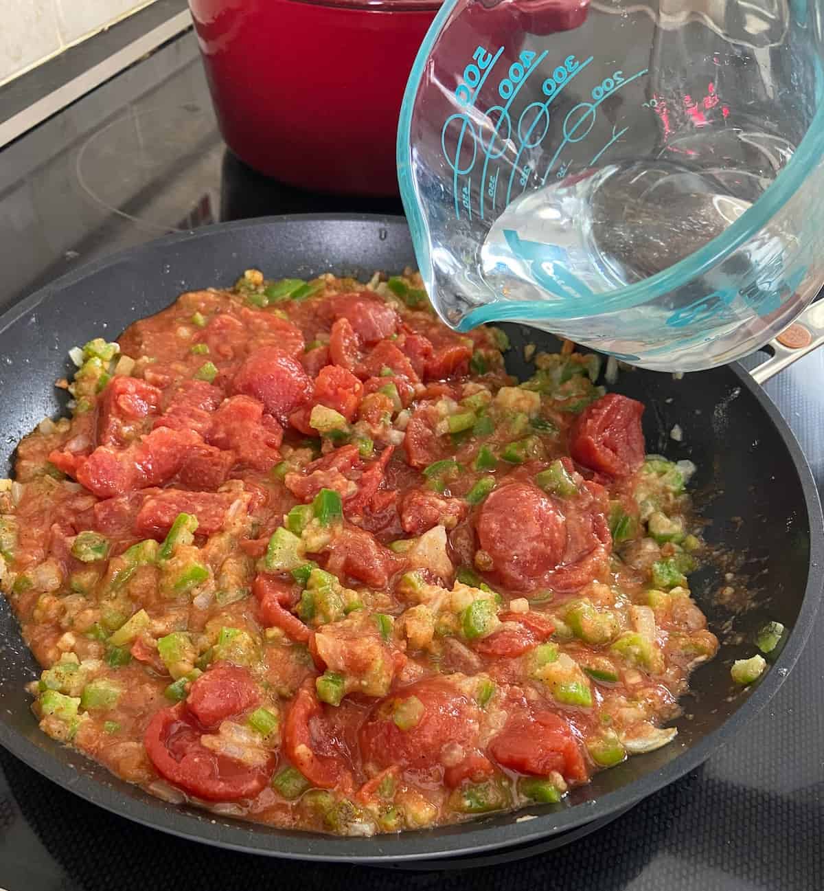 Add stewed tomatoes and water to skillet.