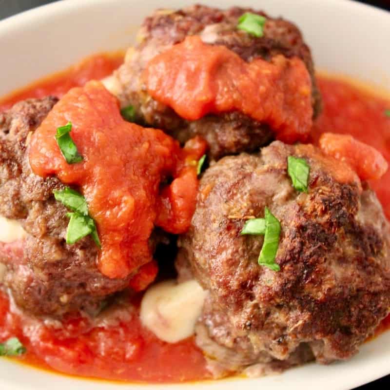 Baked meatballs drizzled with red sauce.