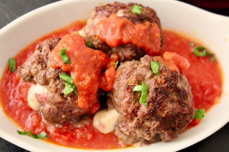 Baked Mozzarella stuffed meatballs in red sauce.