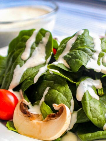 Buttermilk Dill Ranch Dressing on spinach greens with cherry tomatoes and mushroom slices