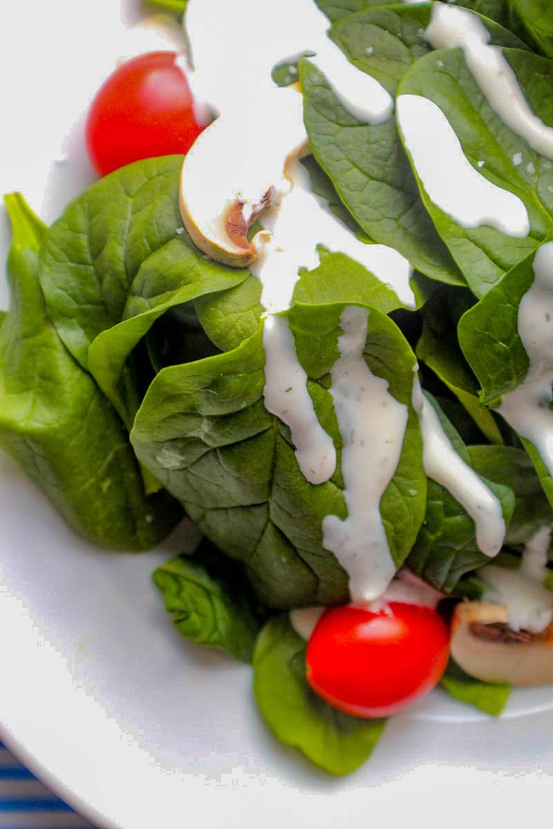Buttermilk Dill Ranch dressing drizzled over spinach greens.