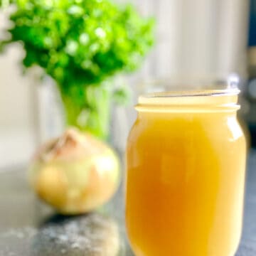 Homemade Chicken Broth in mason Jar on the counter.