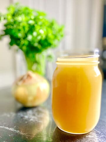 Homemade Chicken Broth in mason Jar on the counter.