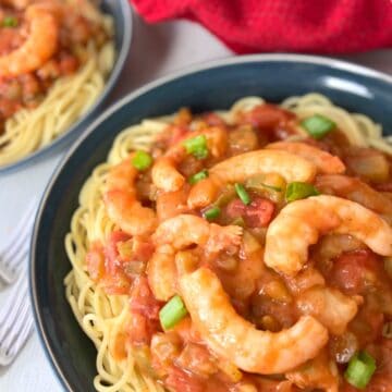 Creole shrimp pasta in blue bowl.