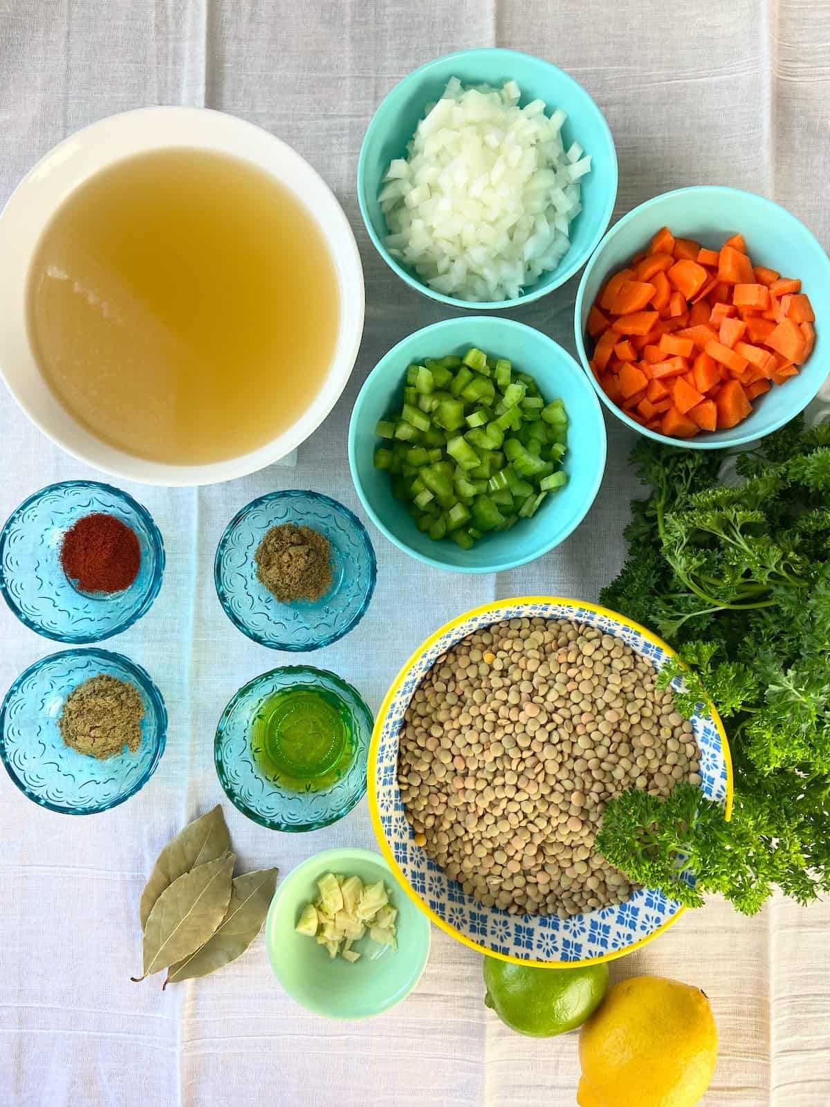 Ingredients for lentil soup on white tablecloth.