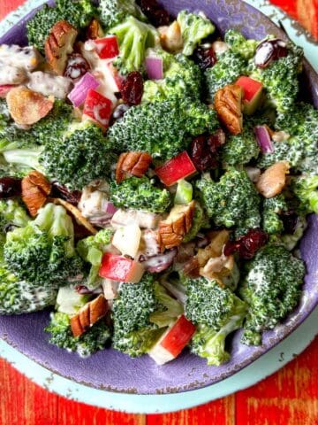 Broccoli Crunch Salad in purple bowl on red wooden table