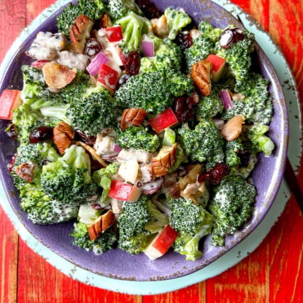 Broccoli Crunch Salad in purple bowl on red wooden table