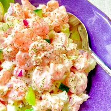 Cold Dill Shrimp Salad in purple bowl with serving spoon.