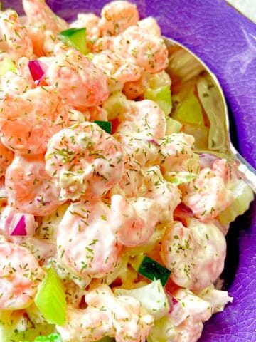 Cold Dill Shrimp Salad in purple bowl with serving spoon.