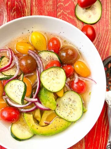 White bowl of marinated vegetable salad.