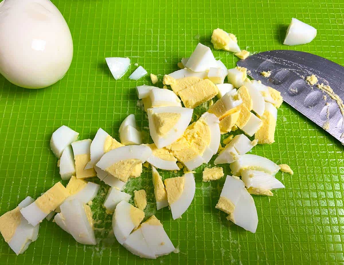 Diced eggs on green cutting board.