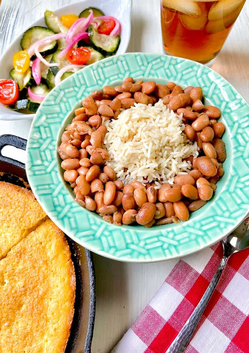 Pinto beans and rice in turquoise bowl on table.