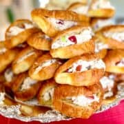 Chicken salad sandwiches on mini croissants stacked on silver platter.