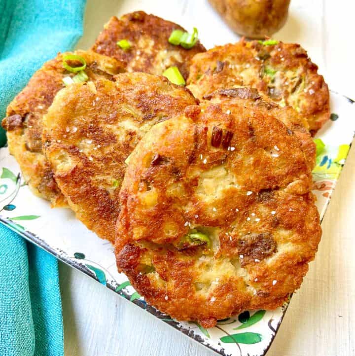 Fried potato cake patties on decorative plate.