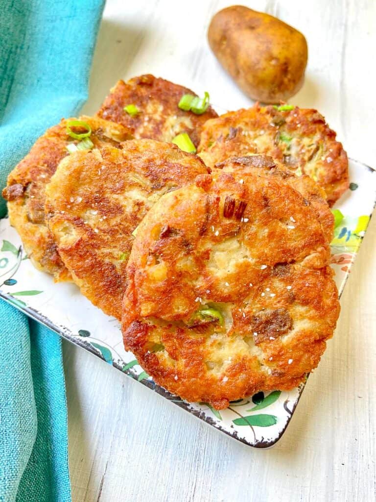 Fried potato cakes on decorative plate.