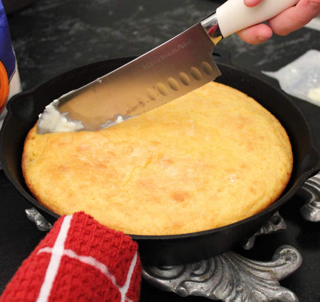 Knife slicing cornbread.