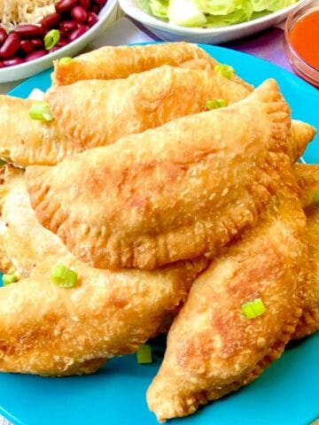 Meat pies on turquoise plate.