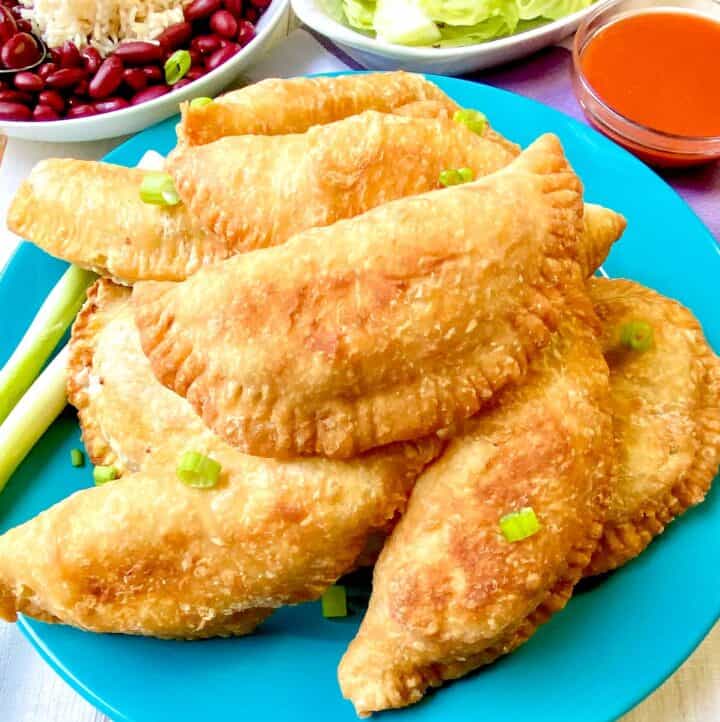 Meat pies on turquoise plate.