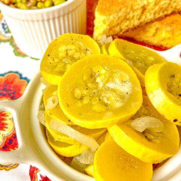 Sauteed yellow squash and onions in white bowl.