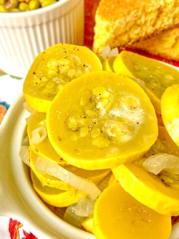 Sauteed yellow squash and onions in white bowl.