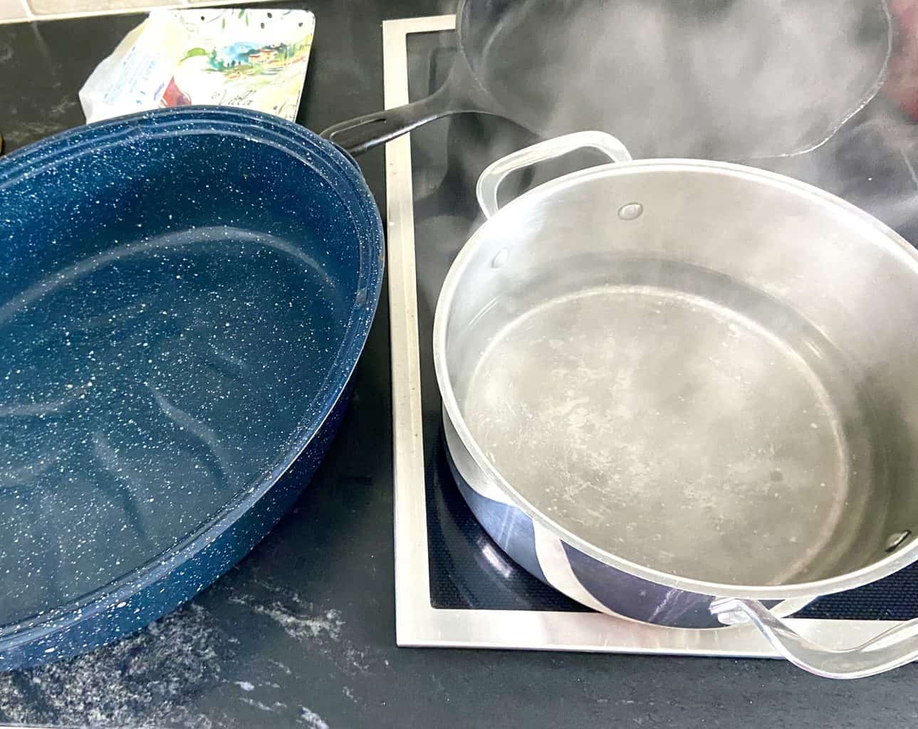 Roasting pan next to pot of boiling water.