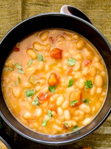 Navy bean soup in black bowl.