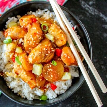 Sweet and sour shrimp in black bowl.