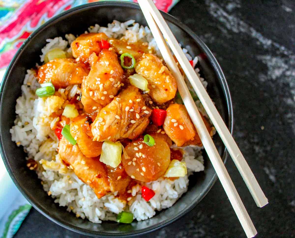 Sweet and sour shrimp in black bowl.