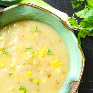 Soup in greeen bowl garnished with parsley.