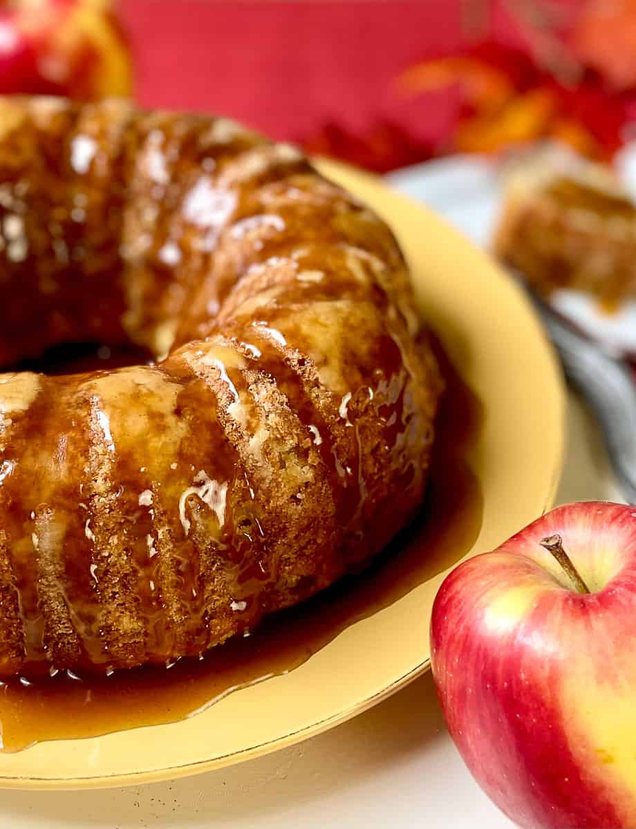 Apple cake with glaze on gold plate.