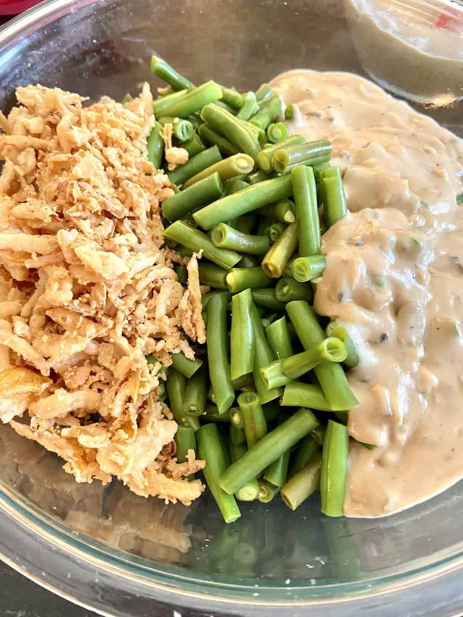 Fried onions, green beans and soup in bowl.