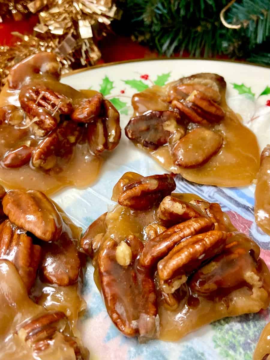 Clusters of pecan pralines on decorative plate.