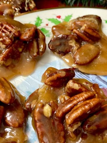 Clusters of pecan pralines onn decorative plate.