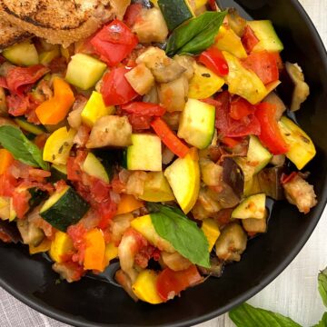 Ratatouille in black bowl closeup.