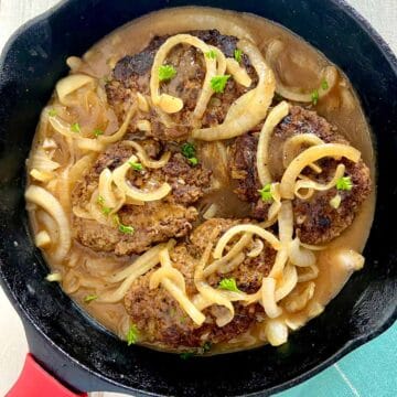 Salisbury hamburger steak in cast iron skillet.